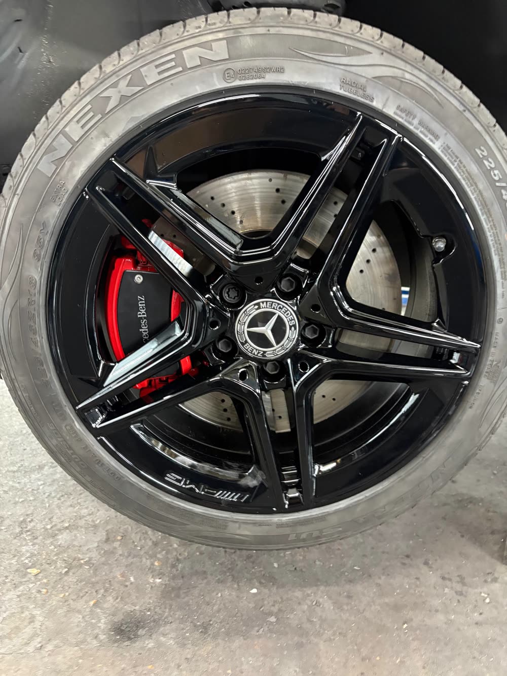Mercedes-AMG alloy wheel refurbished in gloss black with a red caliper behind the spokes