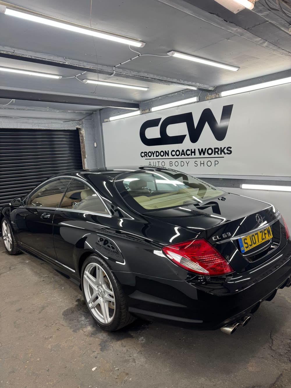 Gloss black Mercedes CL 63 AMG finished in front of the Croydon Coach Works sign
